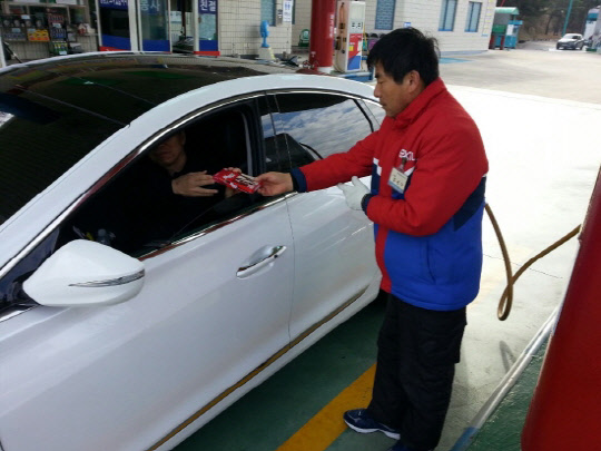 안동(춘천방향)주유소 직원이 고객에게 막대과자를 나눠주고 있다. 안동주유소 제공